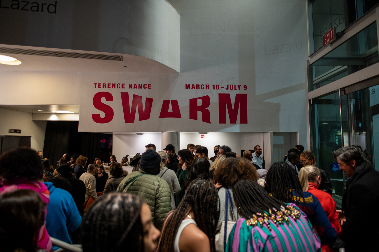 A photo shows a crowd gathering indoors at night, under a large wall text that reads "Terence Nance: Swarm March 10-July 9".