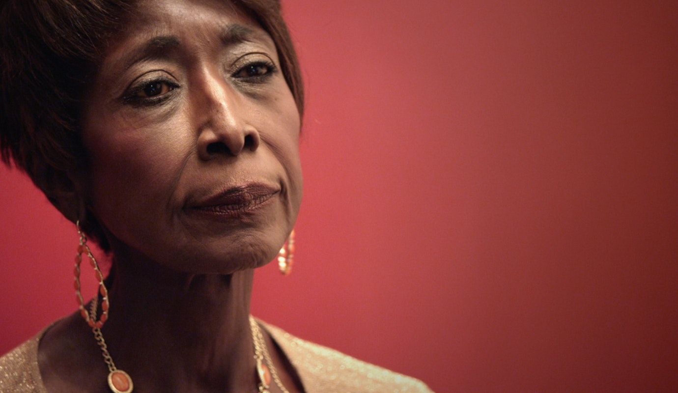 A still from Happy Birthday to a Beautiful Women shows a close-up of an older Black woman. She has a contemplative look on her face.
